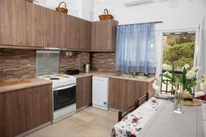 a kitchen with wooden cabinets and a white stove top oven at White Heaven in Lakkíon