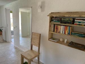 einem Holzstuhl in einem Zimmer mit Bücherregal in der Unterkunft Haus am Pool in Knautkleeberg