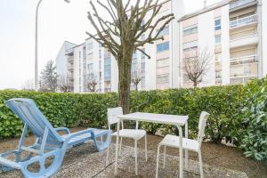 een tafel en stoelen naast een boom bij Le Marpaux in Dijon