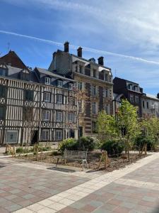 un gran edificio con un banco delante en Hôtel Paulette Rouen Centre Cathédrale en Ruan