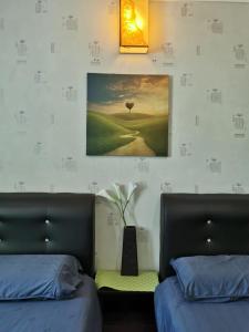 - une chambre avec 2 lits et une photo sur le mur dans l'établissement C 13 Lot 10 Pangkor Leisure Beach Studio, à Île de Pangkor