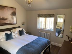 a bedroom with a large bed and a mirror at Pear Tree Cabin in Beaulieu