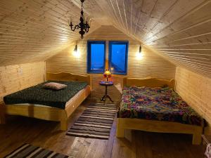 1 dormitorio con 2 camas en una habitación de madera en Casa Brună en Băile Olăneşti