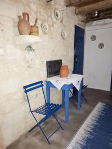 uma mesa azul e uma cadeira num quarto em Apo Petra em Agia Marina Aegina