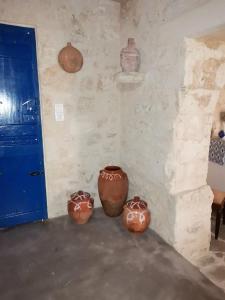 three clay vases sitting on the floor in a room at Apo Petra in Agia Marina Aegina