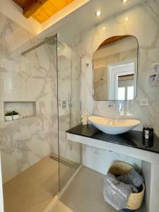 a bathroom with a sink and a glass shower at Paradisia Villas in Tourlos