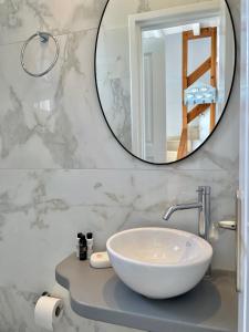 a bathroom with a white sink and a mirror at Paradisia Villas in Tourlos
