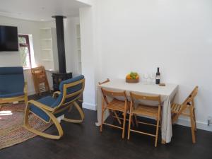a dining room with a white table and chairs at Willow Cottage in Dersingham