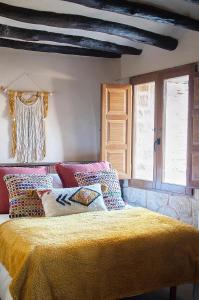 um quarto com uma cama com um cobertor amarelo em Precioso loft rural con estufa de leña panorámica em Torre del Compte