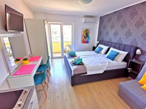 1 dormitorio con cama, escritorio y sofá en Apartments CVITA HOLIDAY - Villa NATALI, en Rogoznica