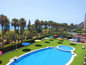 ein großer Pool mit Sonnenschirmen und ein Resort in der Unterkunft ACV - Vistamar III-1ª línea planta 2 Frontal in Oropesa del Mar