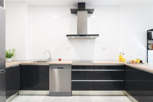 una cucina con armadi neri e lavandino di Puerta de Purchena - Lux&Cool - apartamento a Almería