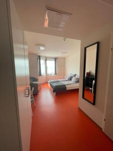 a bedroom with a bed and a mirror in a room at SOVEA Hotel - Braunau in Braunau am Inn