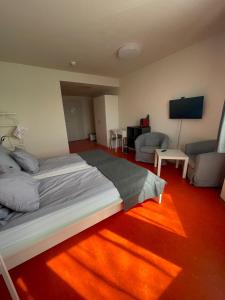 a bedroom with a bed and a living room at SOVEA Hotel - Braunau in Braunau am Inn