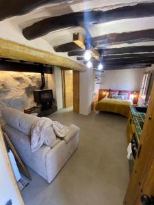 uma sala de estar com um sofá e uma cama em Precioso loft rural con estufa de leña panorámica em Torre del Compte