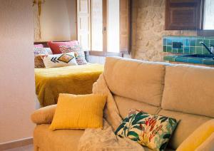 a living room with a couch with pillows on it at Precioso loft rural con estufa de leña panorámica in Torre del Compte