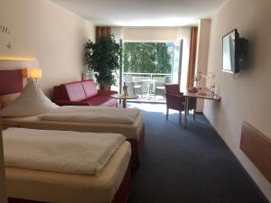 a hotel room with two beds and a living room at Hotel Häfner in Bad Schonborn