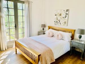 1 dormitorio con 1 cama blanca grande y 2 almohadas en Les Grands Bois, en Pomport