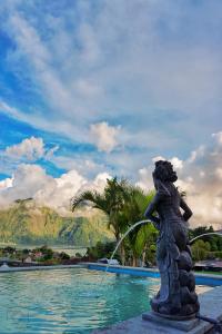 a statue of a woman drinking water from a fountain at Mapa Lake View Bungalow in Kintamani