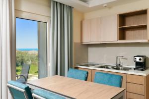 a kitchen with a table and chairs and a window at Supreme Luxury Suites in Skala Potamias