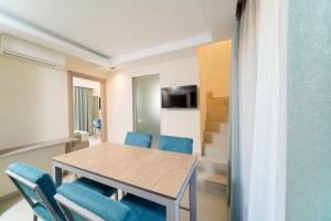 a dining room with a table and blue chairs at Supreme Luxury Suites in Skala Potamias