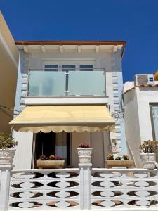 a building with awning and two potted plants at Le case di Nunzia in Lampedusa