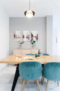 una sala da pranzo con tavolo in legno e sedie blu di Puerta de Purchena - Lux&Cool - apartamento a Almería