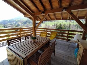a wooden deck with a table and chairs on it at Chez Alphonse in Thônes