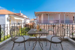 a patio with a table and chairs on a balcony at Adonis Hotel in Pefkohori