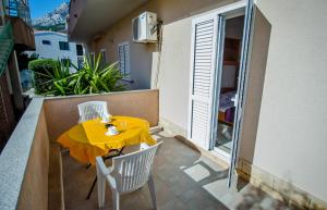 a yellow table and chairs on a balcony at Villa Nedo in Baška Voda