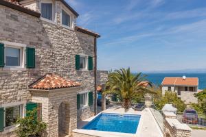 a house with a swimming pool next to a building at Villa Milena with Pool and Sea View in Crveni Vrh