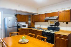 a kitchen with wooden cabinets and a table and a refrigerator at Casa la Feria - Céntrico in Aguascalientes