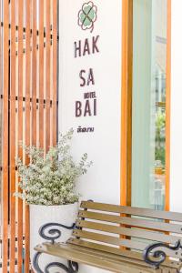 a wooden bench sitting in front of a door with a plant at Haksabai Hotel Chiangrai โรงแรมฮักสบาย เชียงราย in Ban Huai Bong