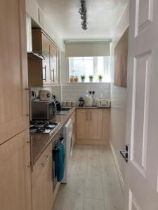 a kitchen with wooden cabinets and a stove top oven at Picturesque Mews Apartment Perfect Location Steps From Harbour and Beaches in Torquay
