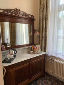 a bathroom with a sink and a large mirror at Hotel Seeufer in Plön