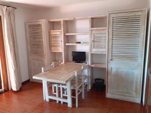 - une salle à manger avec une table, des chaises et un ordinateur dans l'établissement Chrysalis Bay, à Porto Cervo