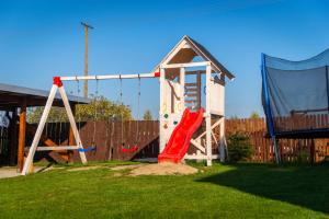 a playground with a slide and a swing at Domki u Karola Domek nr 1 in Mikołajki