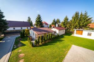 a house with a yard with grass and trees at Domki u Karola Domek nr 1 in Mikołajki