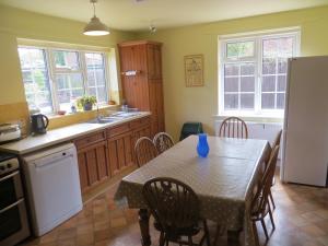 a kitchen with a table with chairs and a refrigerator at 44 Sea Lane in Hunstanton