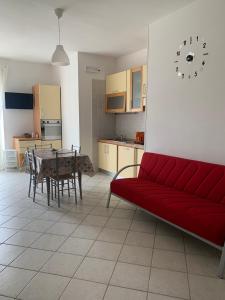 a living room with a red couch and a table at Appartamento D&G in Rodi Garganico