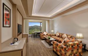 a living room with a couch and a table at The Orchid Manali - a Boutique Hotel in Manāli