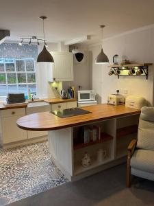 a kitchen with a table and a microwave in it at Stratton Gardens in Bude