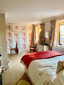 a bedroom with a bed with a red blanket at The Grange in North Cadbury