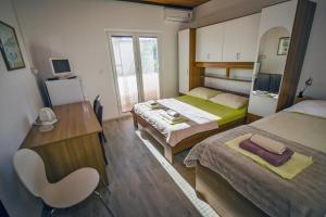 a bedroom with two beds and a desk and a chair at Villa Nedo in Baška Voda