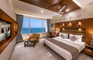 a bedroom with a large bed and a large window at Dwarkadhish Lords Eco Inn in Dwarka