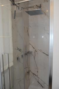 La salle de bains est pourvue d'une douche avec une porte en verre. dans l'établissement Exclusive Home 1, à Misano Adriatico