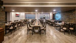 a large dining room with tables and chairs at Dwarkadhish Lords Eco Inn Dwarka - Pure Veg in Dwarka