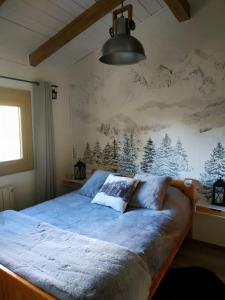 um quarto com uma cama com um mural de montanha na parede em Chalet de charme entre Genève, Annecy et stations em Viuz-en-Sallaz