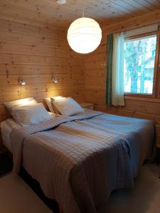 ein Schlafzimmer mit einem Bett in einem Holzzimmer in der Unterkunft Kantokelo B2 in Ylläsjärvi