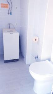 ein weißes Bad mit WC und WC-Papierspender in der Unterkunft Apartamento playa LLevant mejor zona Salou in Salou